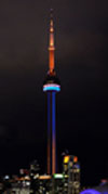 The CN Tower lit up at night in blue and orange